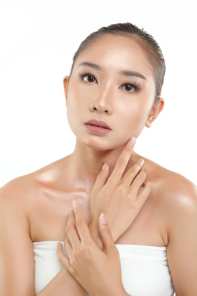 a woman in a white top with her hands on her chest